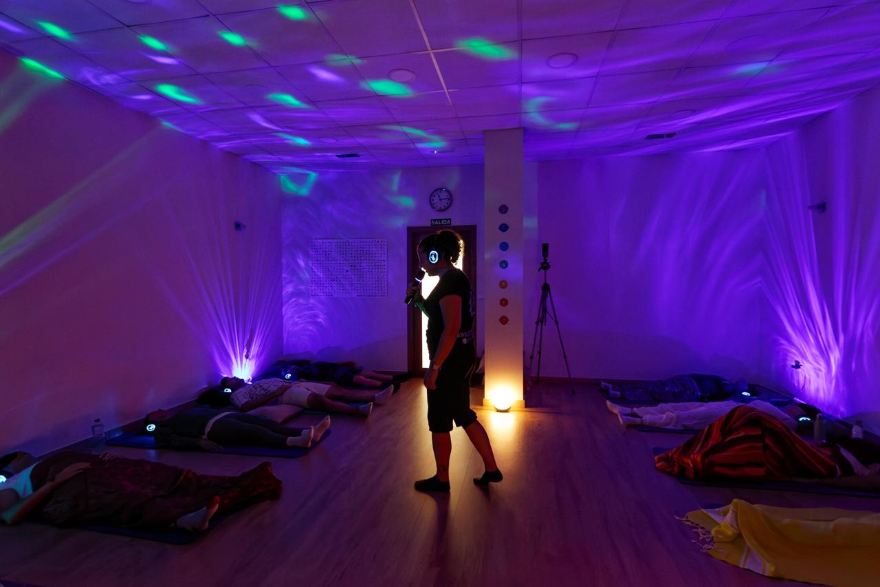 Sala preparada con esterillas e iluminación violeta para un evento SomAire®